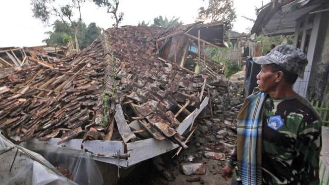 Seorang warga menyaksikan rumah mereka ambruk terdampak gempa Cianjur