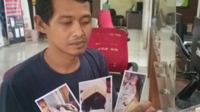 Suparman (38), menunjukkan foto putranya berusia delapan bulan yang kelingking tangannya diduga digunting oknum perawat RS Muhammadiyah Palembang saat membuat laporan di Polres Kota Besar Palembang, Sumatera Selatan, Sabtu, 4 Februari 2023.