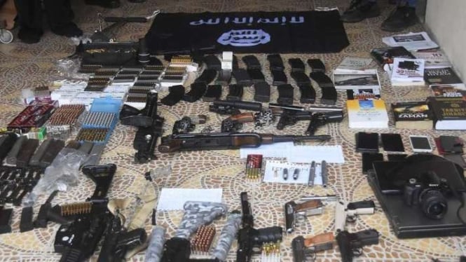 Sejumlah anggota Densus 88 menunjukkan barang bukti senjata api dan barang bukti lainnya milik terduga teroris berinisial DE yang ditangkap di Bekasi, Jawa Barat, Senin, 14 Agustus 2023.